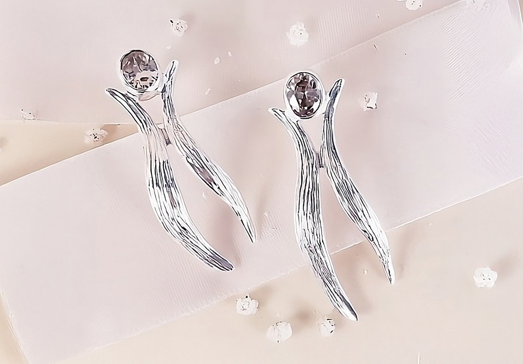 brincos de prata e diamante sobre fundo branco